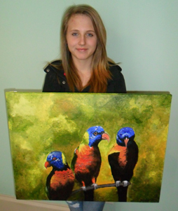 A young artist holding a canvas painting of three colourful tropical birds.