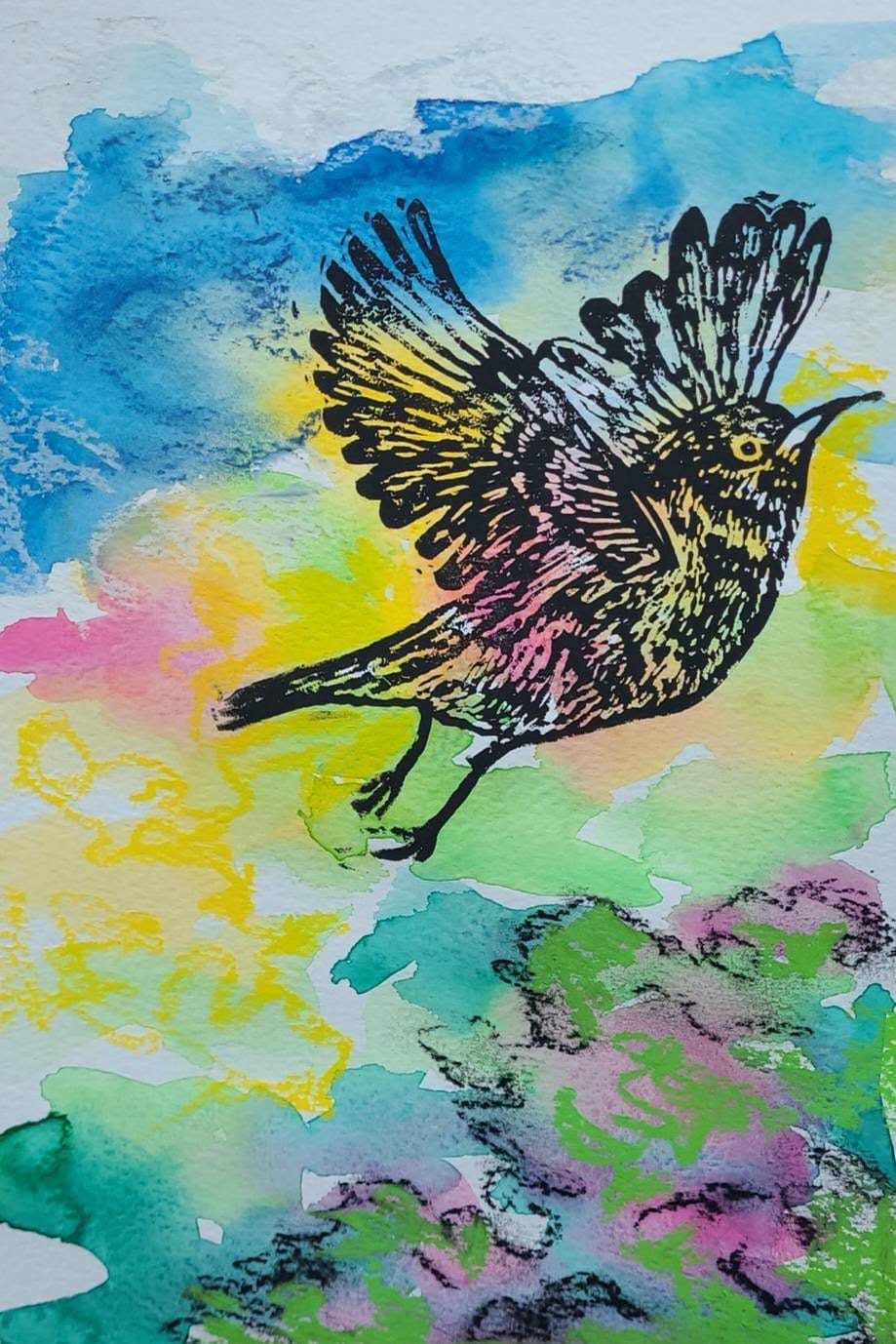 A lino-cut print of a bird in flight over bright watercolour washes.